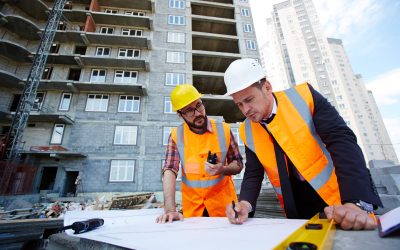 Pointing at sketch Modern engineer pointing at sketch in blueprint while explaining it to colleague